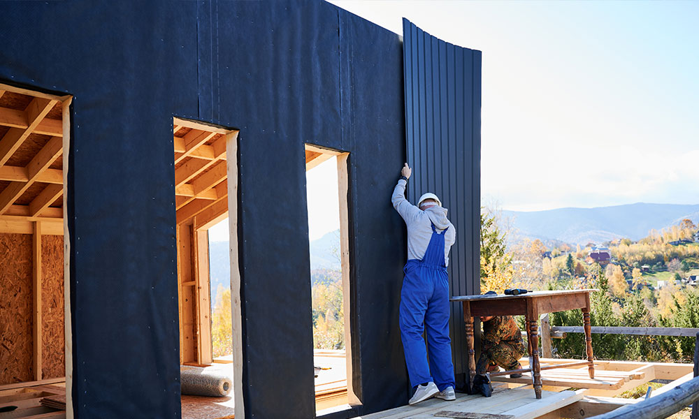 Worker installing vertical metal siding on a residential project by Wolf River Construction, ensuring durability and modern design.