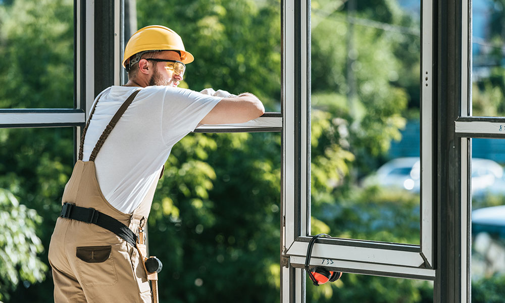 Construction worker installing energy-efficient windows for a project by Wolf River Construction, ensuring quality and durability.