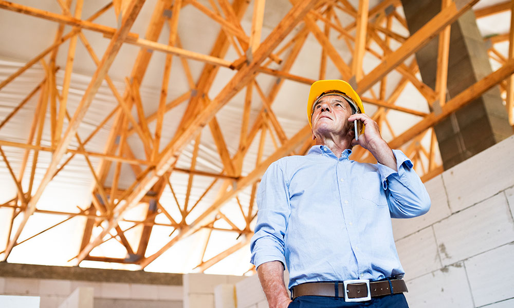 Construction inspector assessing roofing framework at a Wolf River Construction project site, ensuring high-quality workmanship, safety, and structural integrity. Construction inspector assessing roofing framework at a Wolf River Construction project site, ensuring quality and structural integrity.