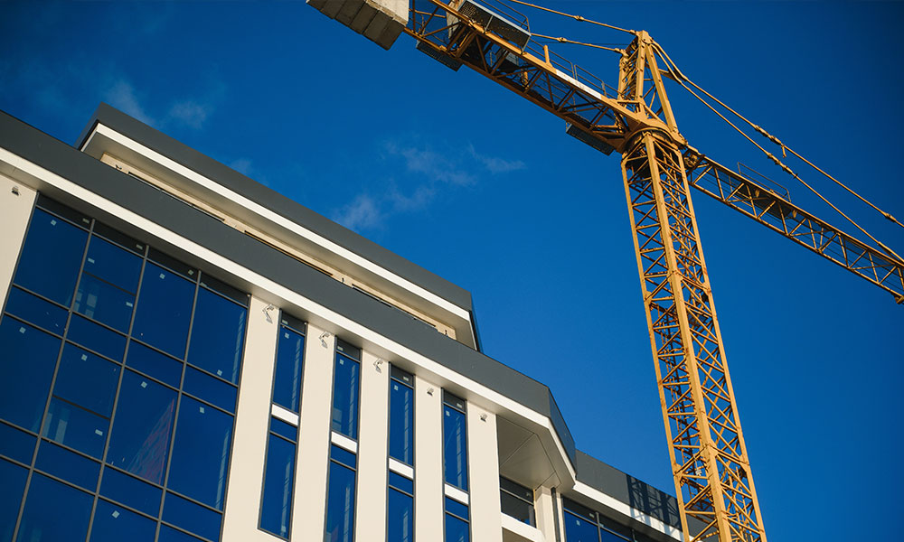 Modern commercial building under construction with a crane, a Wolf River Construction project showcasing quality and precision. Modern commercial building under construction with a crane, a Wolf River Construction project showcasing quality and precision.